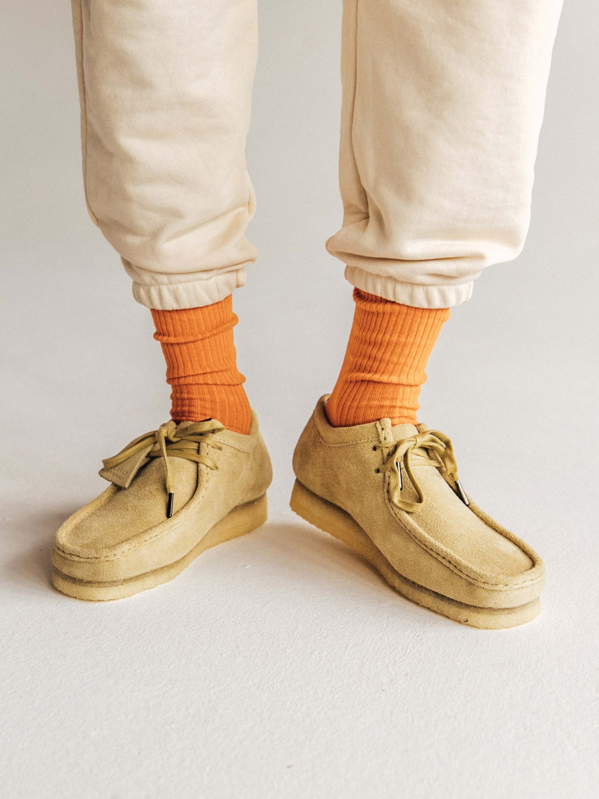 Gerippte orangefarbene Socken mit Karottenmuster und Saftflecken