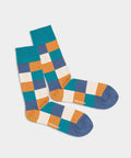 Bunte Socken mit Ocean Chess Schachbrettmuster am Strand